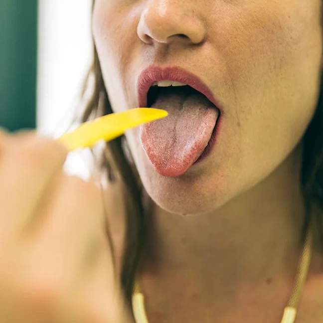 Patient extending tongue during oral cancer screening